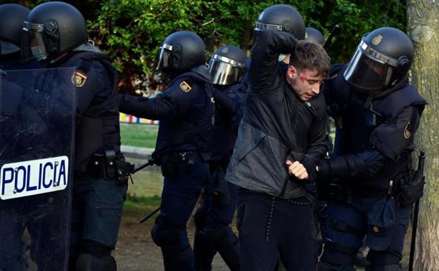 Galería. La Policía detiene a una de las personas implicadas en los altercados.