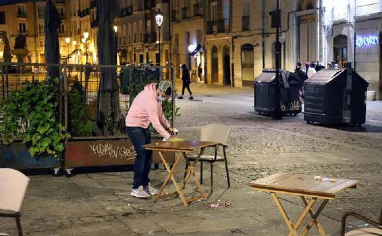 Un hostelero recoge la terraza antes del toque de queda en Burgos.