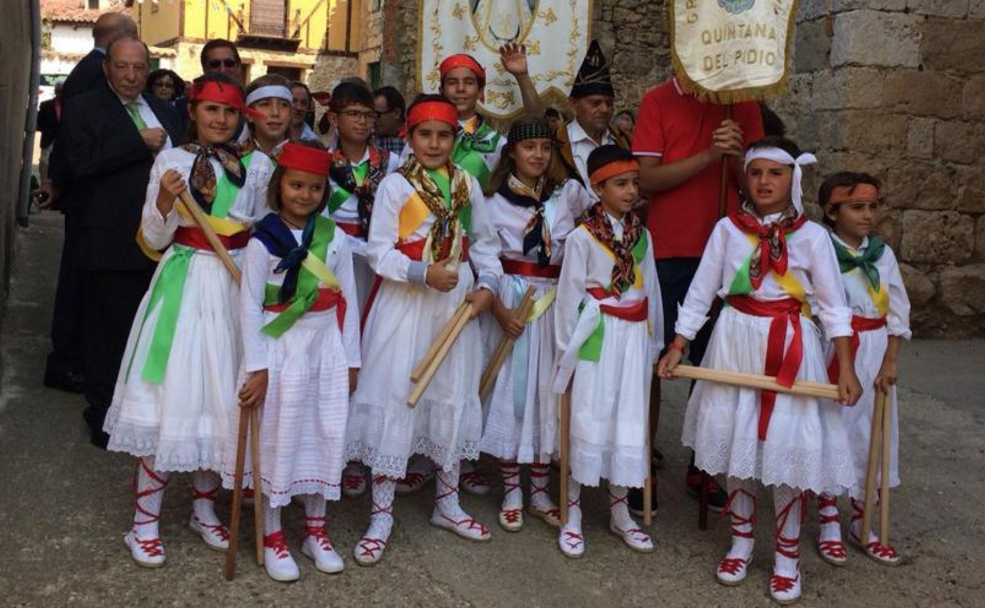 Danzantes tradicionales con palos y sonajas.