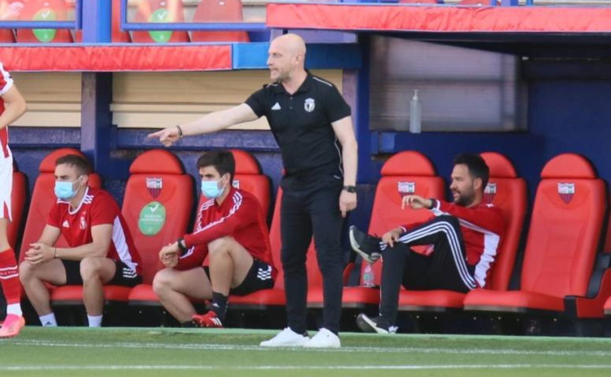 Calero da instrucciones a sus jugadores en el banquillo del Burgos CF.