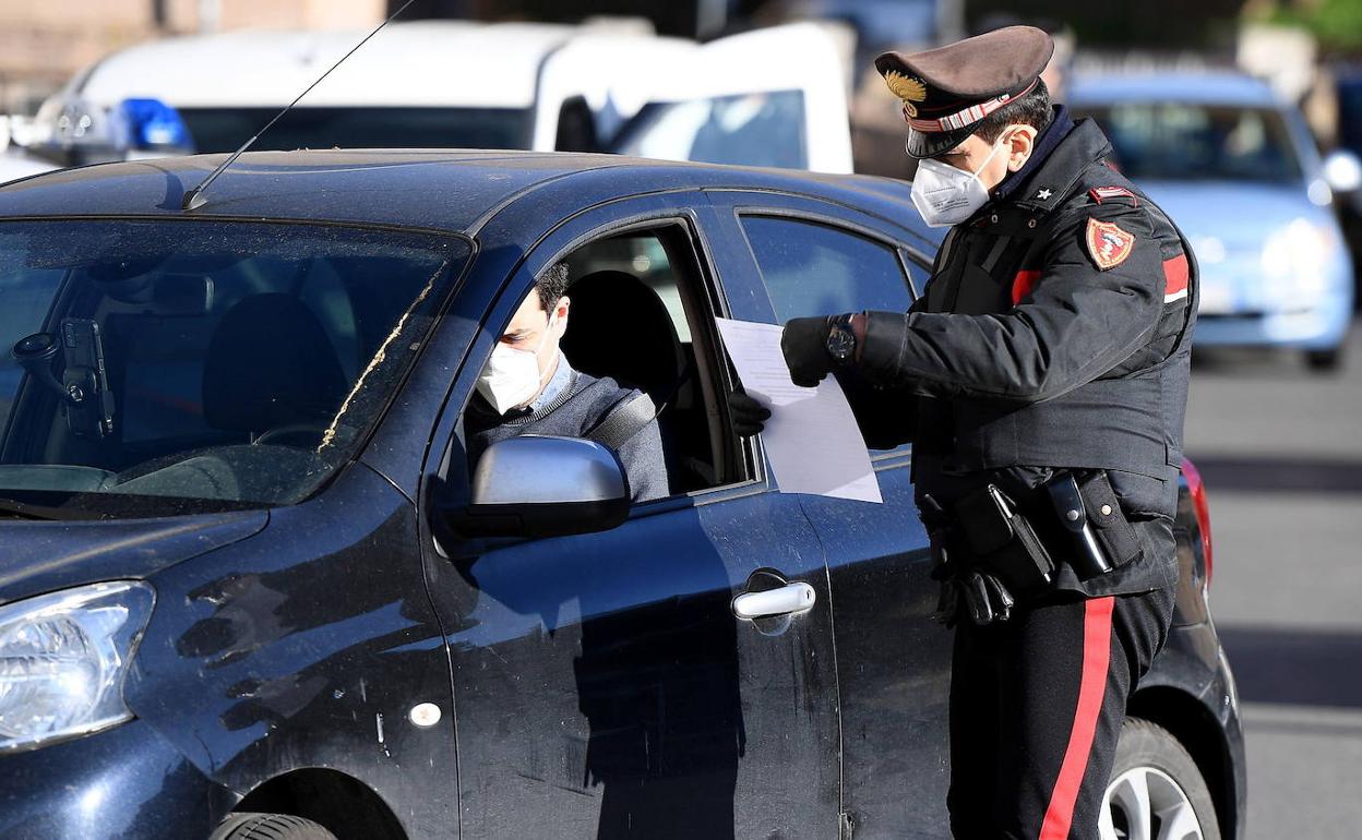 Un policía italiano comprueba la documentación de un conductor.