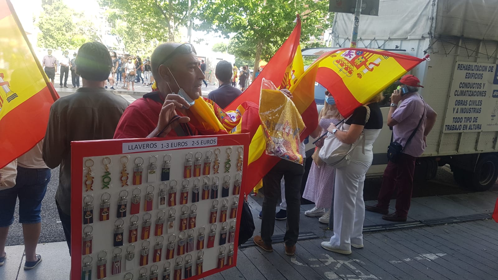 Un vendedor ofrece llaveros a los asistentes a la concentración en la madrileña plaza de Colón.