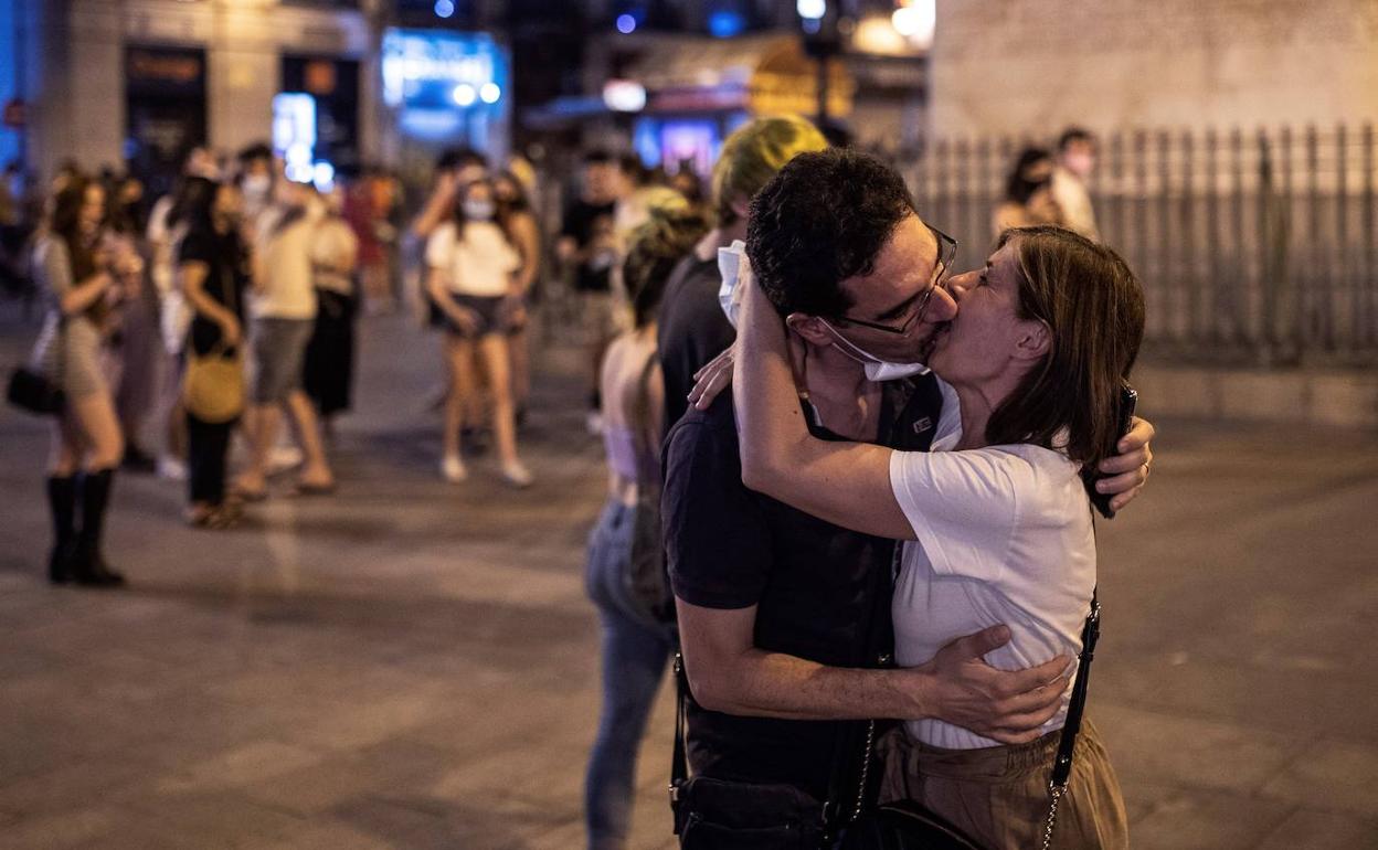 Dos personas se besan en la primera noche sin mascarillas obligatorias.