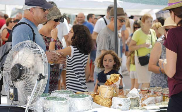 Una niña contempla uno de los puestos de la Feria del Queso.