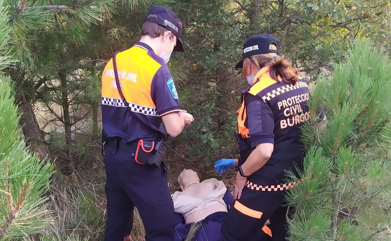 Dos voluntarios encuentran el maniquí escondido en un simulacro dirigido.