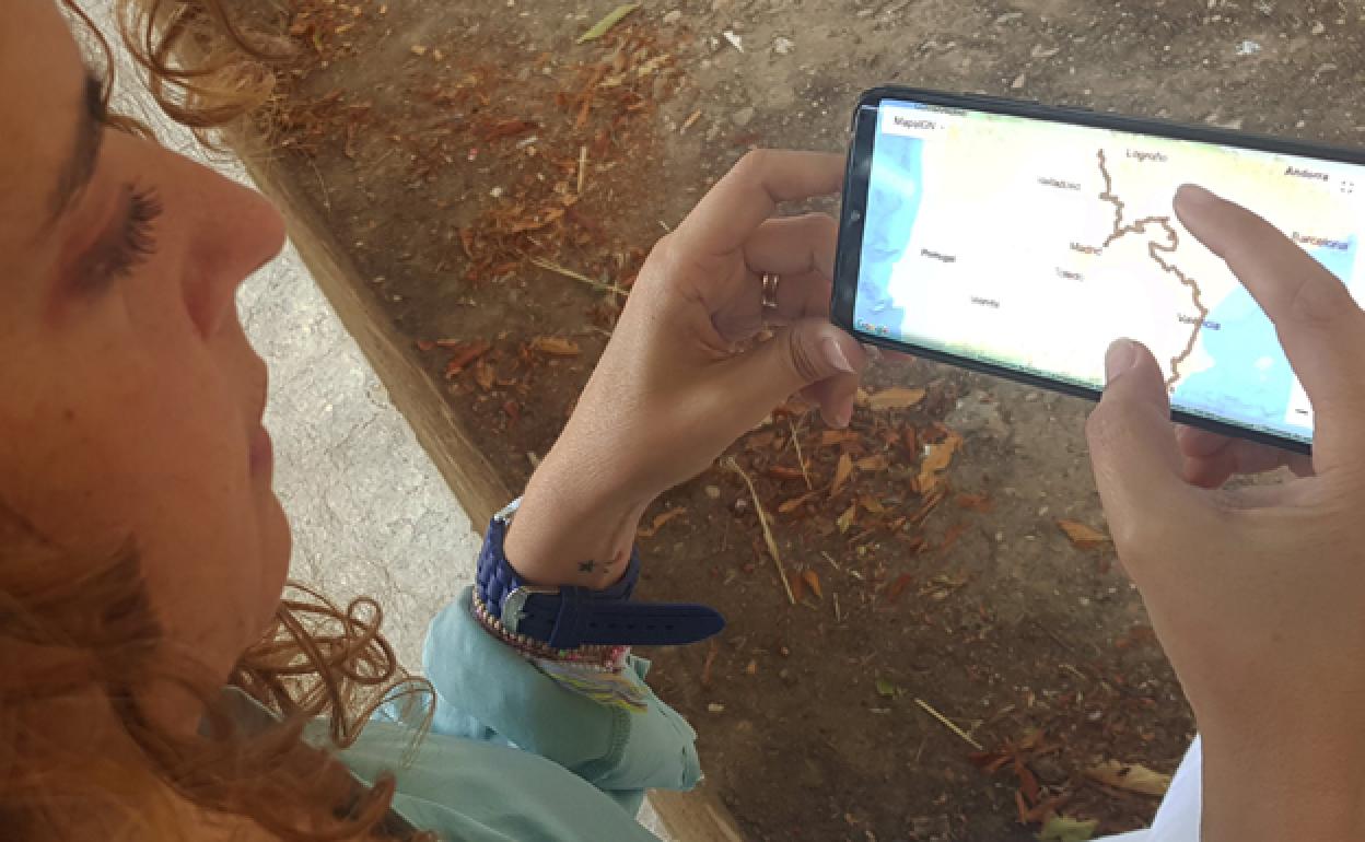 Una joven consulta los tracks actualizados del Camino del Cid. 