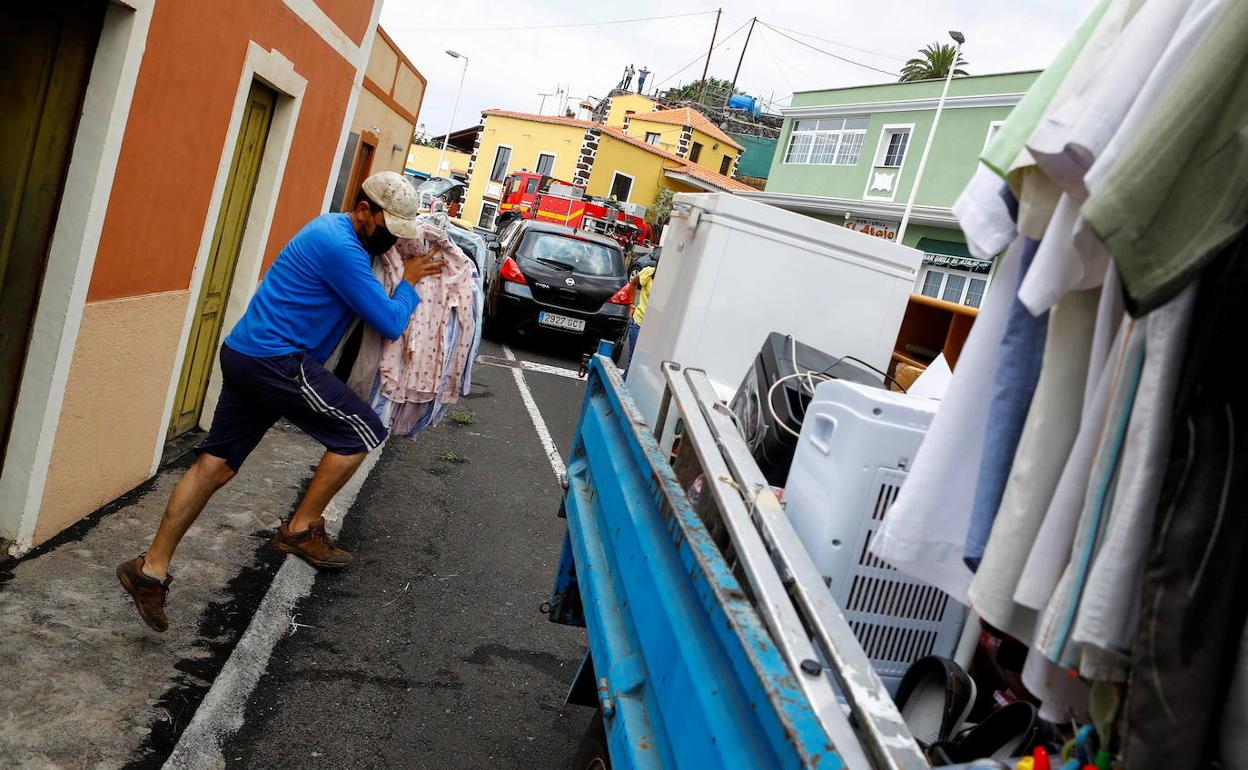 Un hombre saca las pertenencias de su casa antes de ser evacuado por la proximida de la lava del volcán en la isla de La Palma.