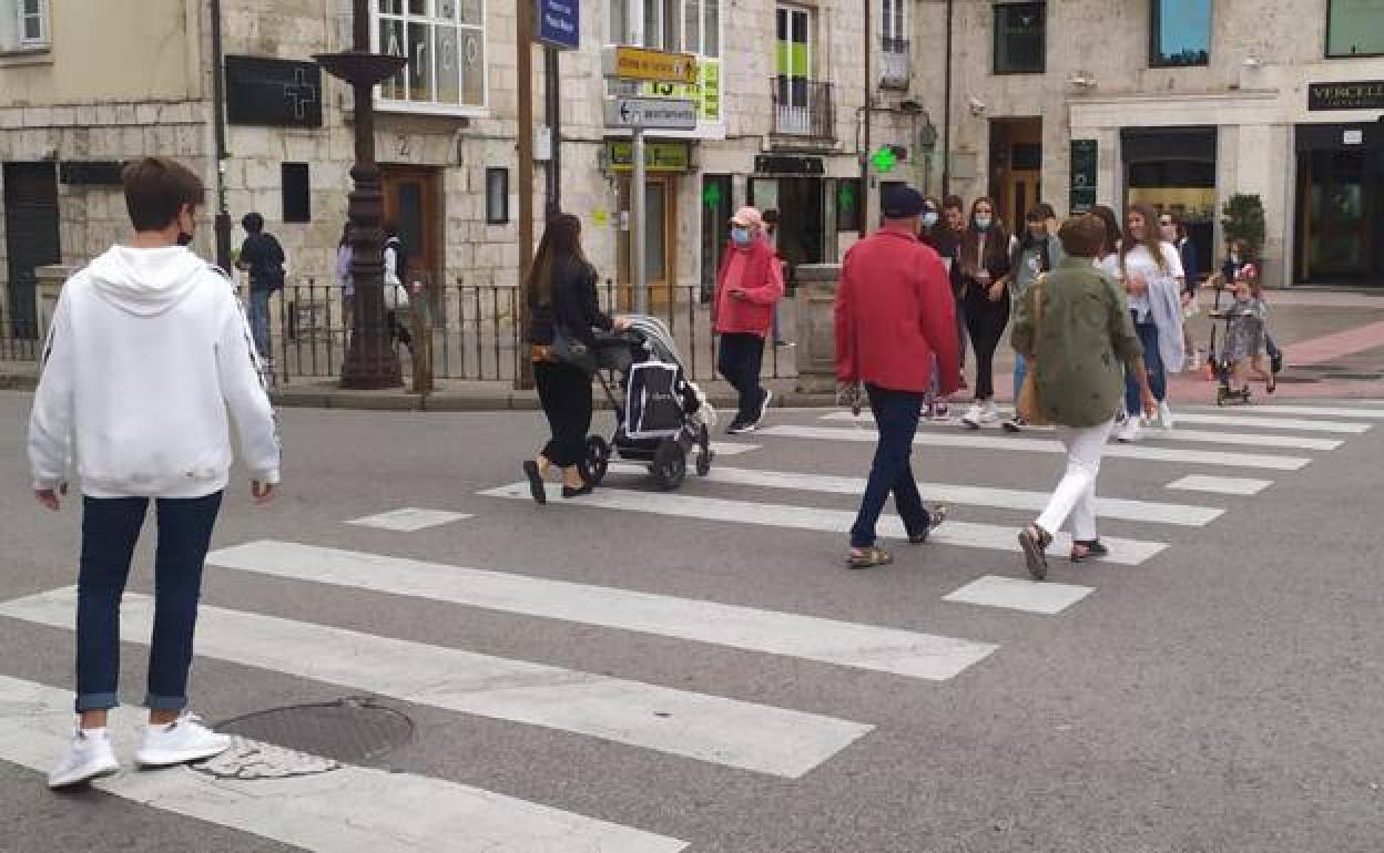 Varios ciudadanos cruzan este miércoles un paso de peatones por el centro de Burgos. 