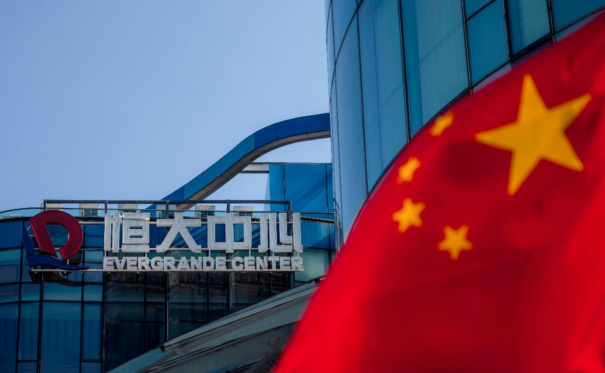 Vista de la bandera china junto a la sede de la constructora Evergrande en Shanghai.