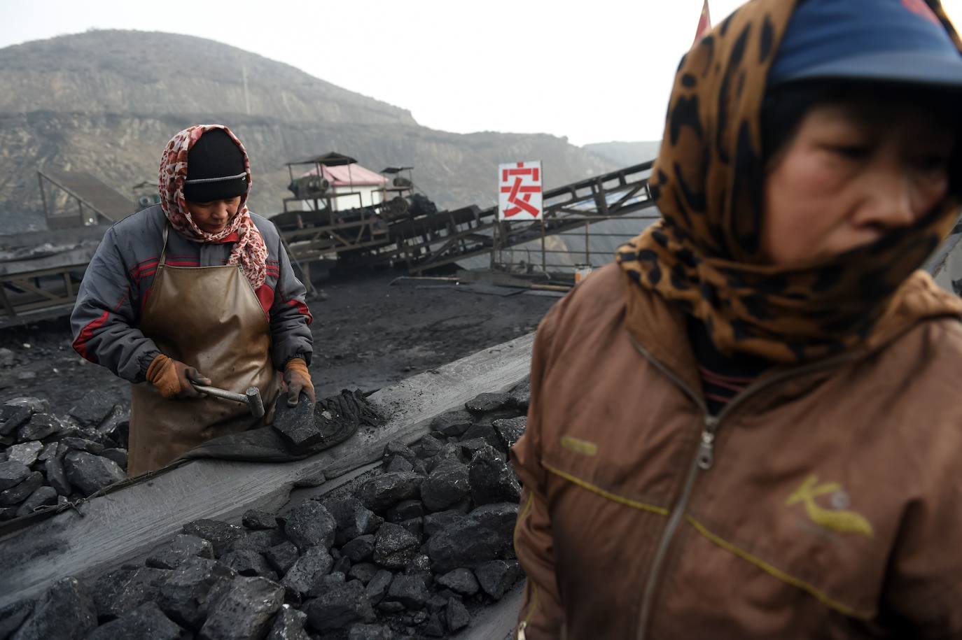 Trabajadores clasificando carbón en una cinta transportadora, cerca de una mina de carbón en Datong, en la provincia de Shanxi, en el norte de China. La promesa de Xi Jinping de eliminar las emisiones para 2060 completa una pirueta diplomática que lleva a China al corazón de la agenda verde global.
