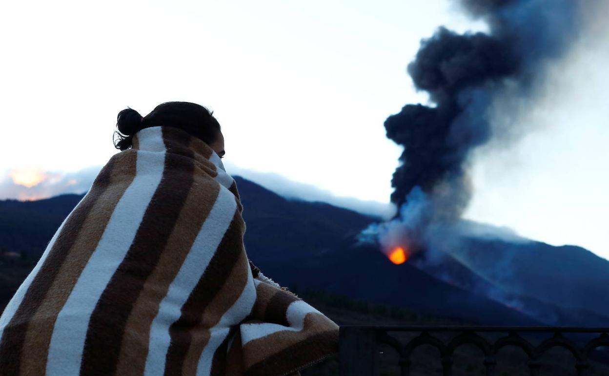 Una mujer observa el volcán de La Palma desde el mirador de Tajuya. 