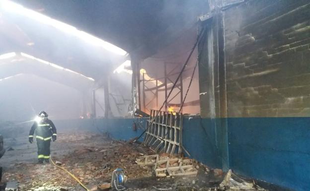 Un bombero de Aranda inspeccion una de las naves afectadas por el fuego.