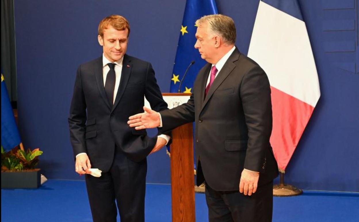 Orban estrecha la mano a Macron.