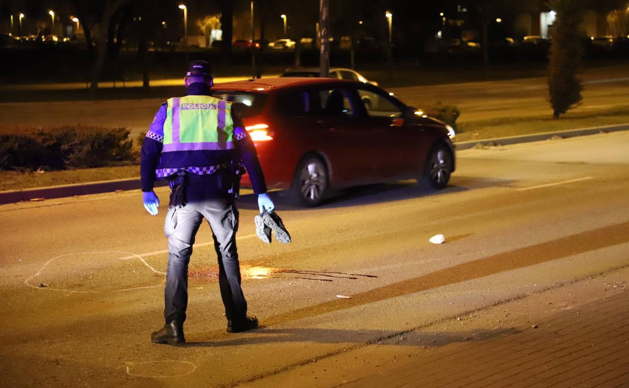 Un policía local recoge los zapatos de la víctima en el atropello de la calle Esteban Sáez Alvarado.