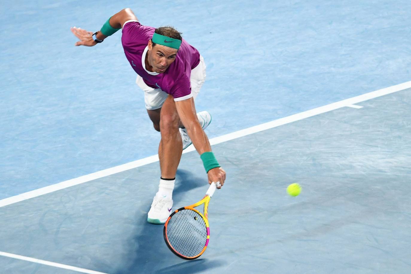 Nadal se agacha para devolver una bola.