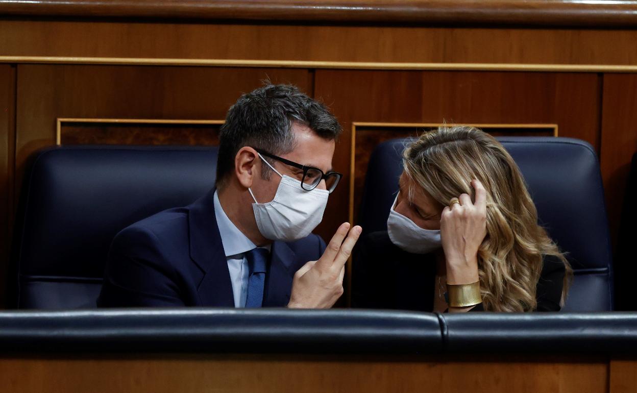 El ministro de Presidencia, Félix Bolaños (i), conversa con la ministra de Trabajo, Yolanda Díaz (d), durante el pleno del Congreso de los Diputados en el debate de la reforma laboral.