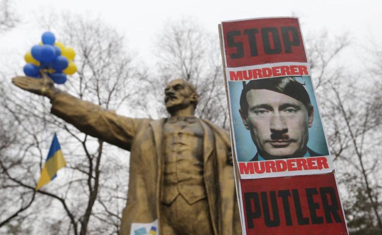 Cartel contra Putin frente a un monumento de Lenin.