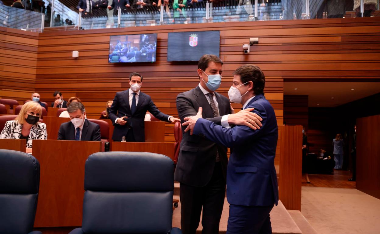 Alfonso Fernández Mañueco se abraza con Ángel Ibáñez antes de sentarse en su escaño. 