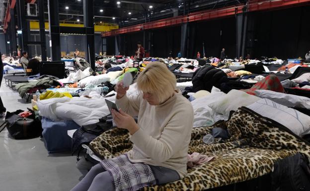 Una mujer ucraniana se peina en el campo de refugiados en la Global Expo de Varsovia.