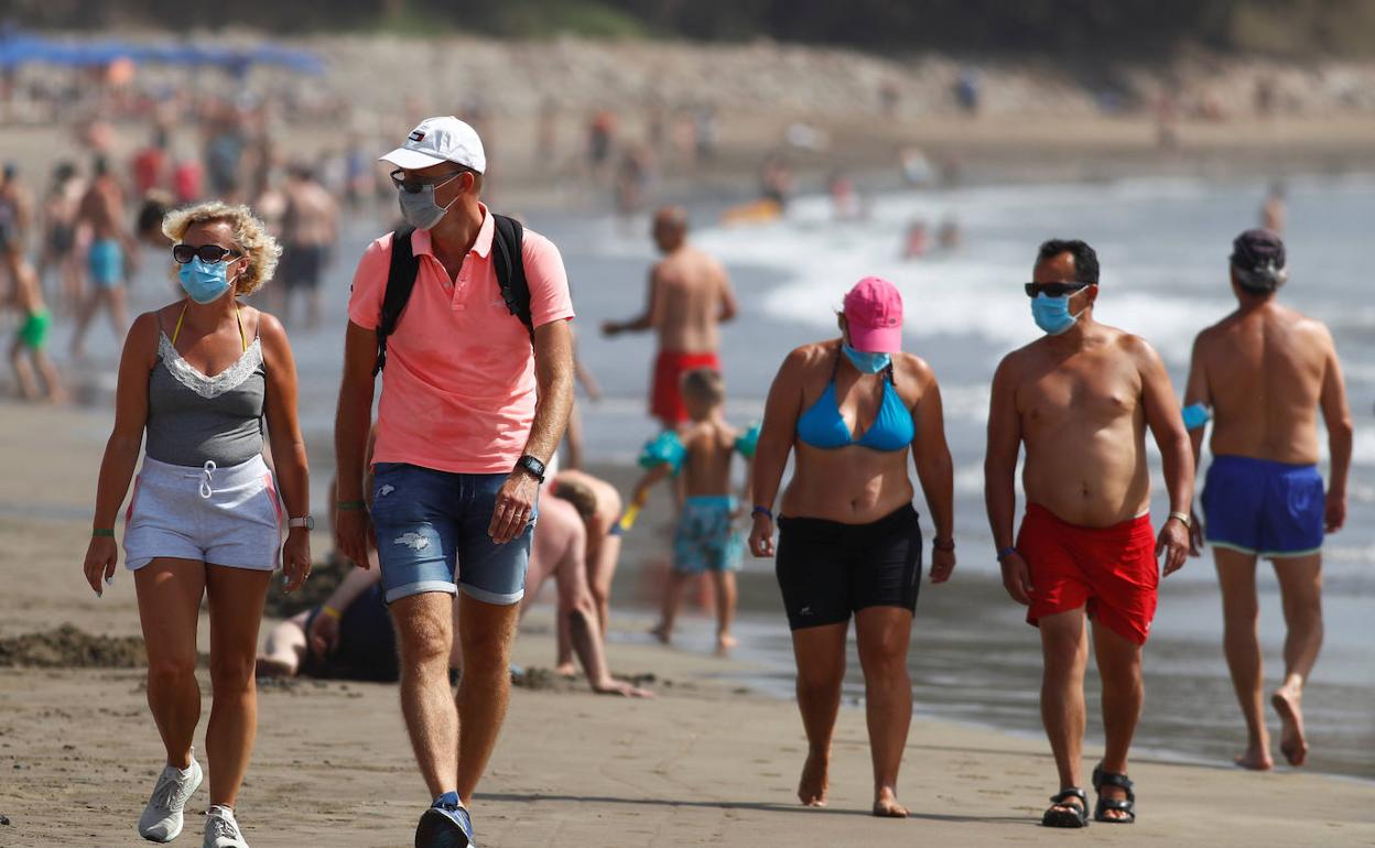 Turistas paseand por una playa de Gran Canaria.