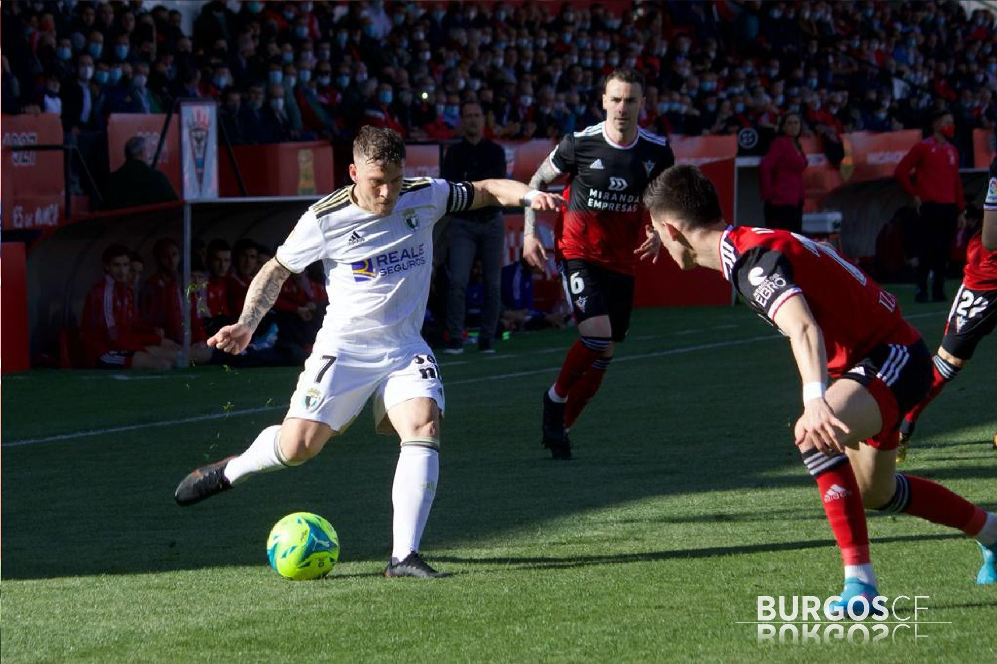 Juanma golpea el balón en presencia del defensor del Mirandés.