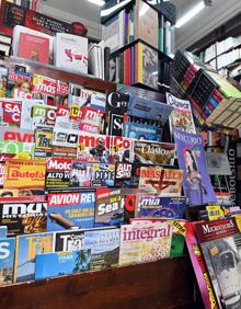 Imagen secundaria 2 - Arriba, Pilar responsable de la librería; abajo, libro y revistas. 