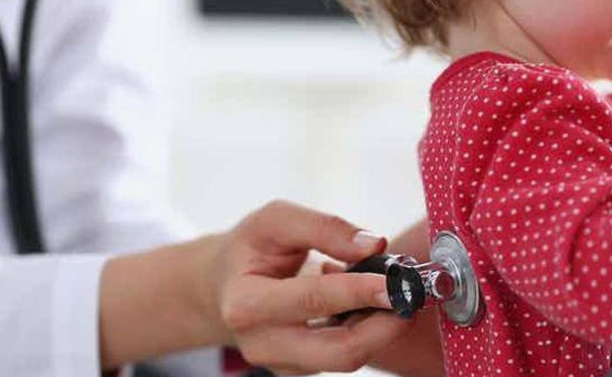 Una pediatra examina a una niña.