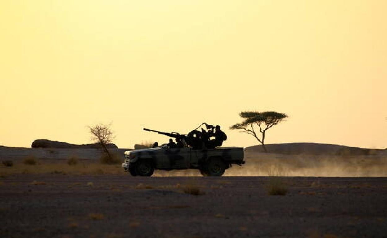 Los soldados del Frente Polisario conducen una camioneta montada con un arma antiaérea durante la puesta de sol en Bir Lahlou.