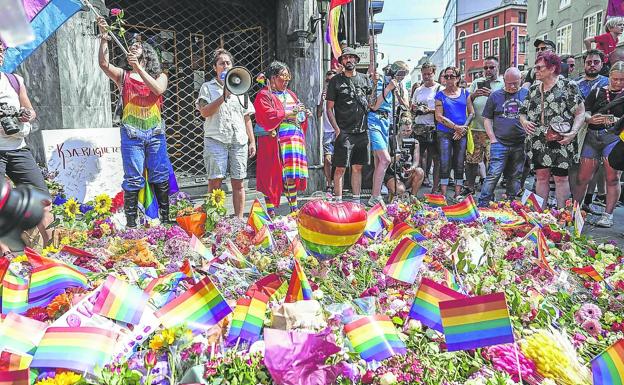 Una multitud de personas protestan por el atentado en un pub gay que acabó con la vida de dos personas, a las que se les dedicó una ofrenda floral. 