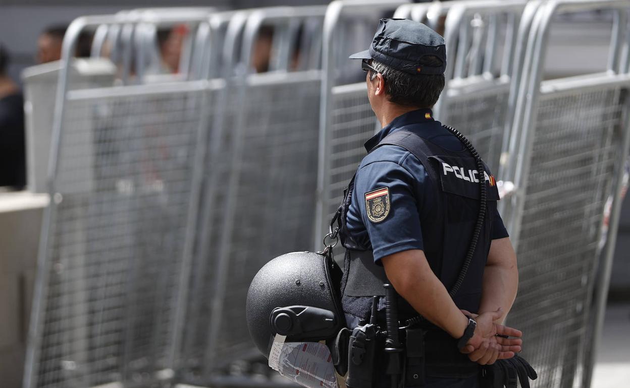 Un policía vigila varias vallas preparadas para el dispositivo de seguridad de la cumbre de la OTAN en Madrid.