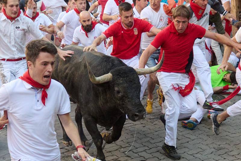 Los mozos corren ante los toros de la ganadería de José Escolar durante el tercer del encierro de San Fermín.