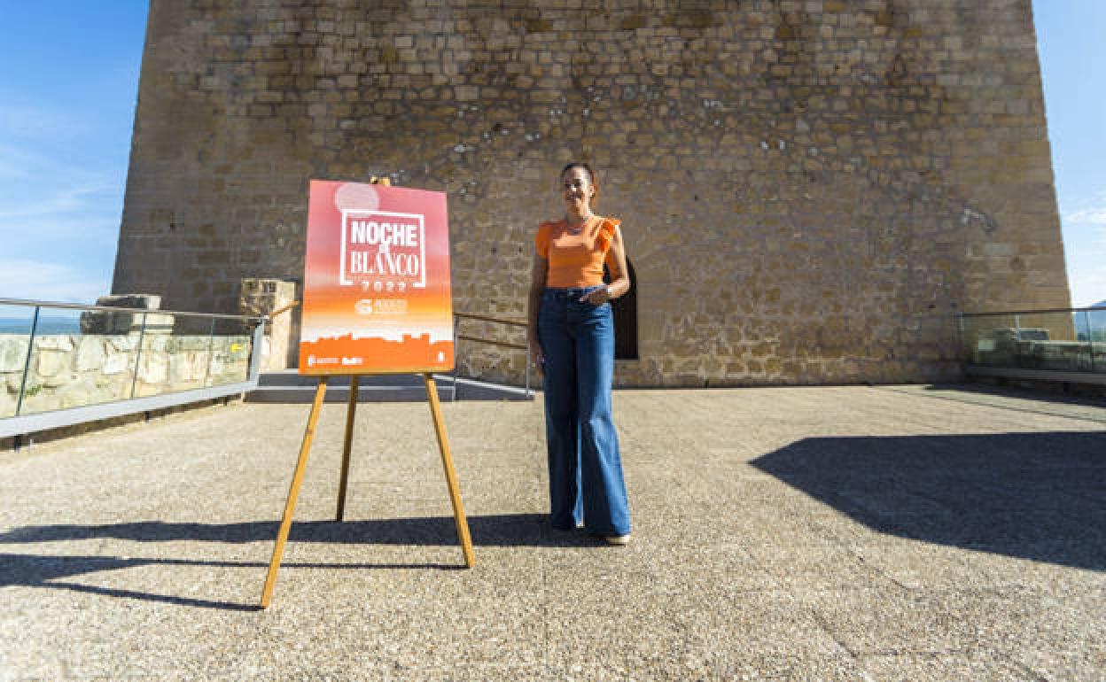 Nerea Angulo, concejala de Turismo del Ayuntamiento de Medina de Pomar , junto al cartel de la 'Noche en blanco'.