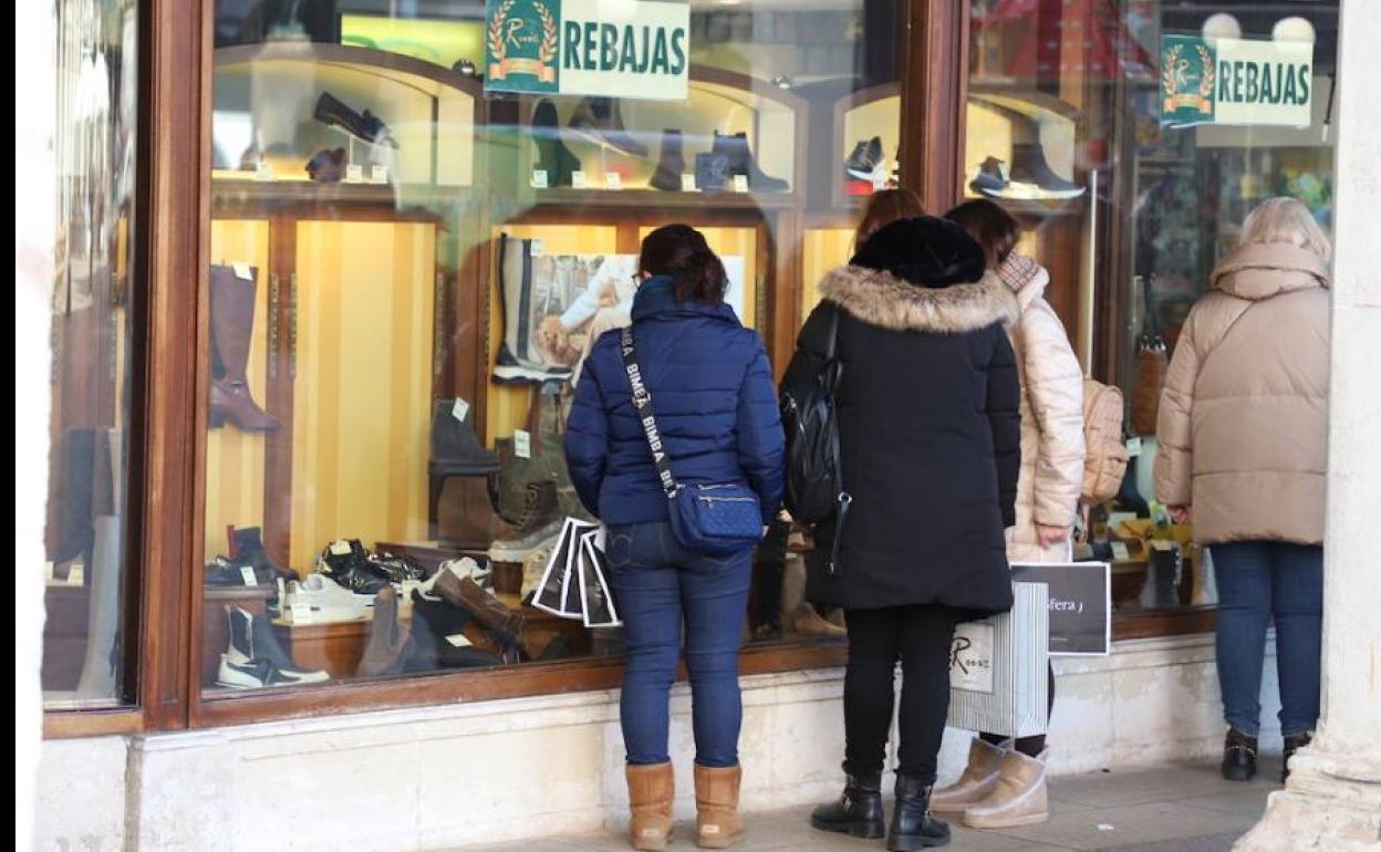 Burgaleses en un escaparate en periodo de rebajas.