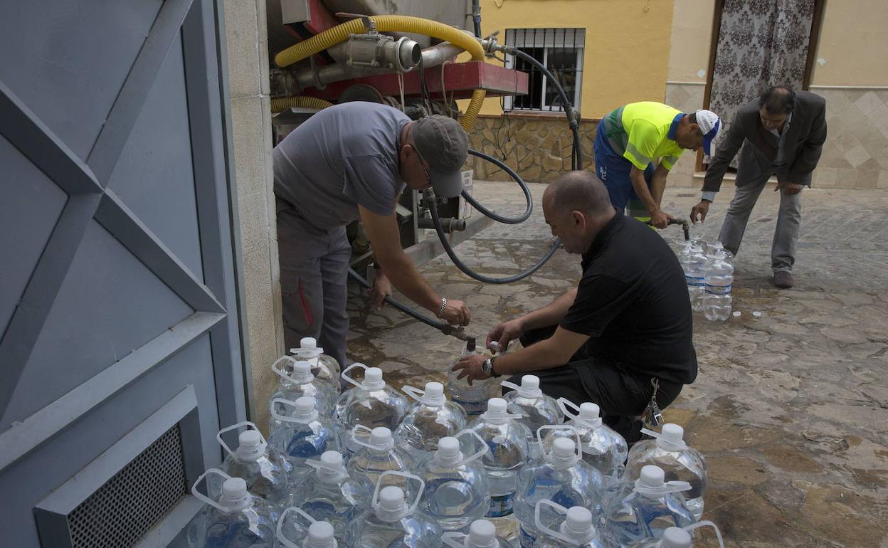 Imagen de archivo de vecinos rellenando garrafas con agua de un camión cisterna. 