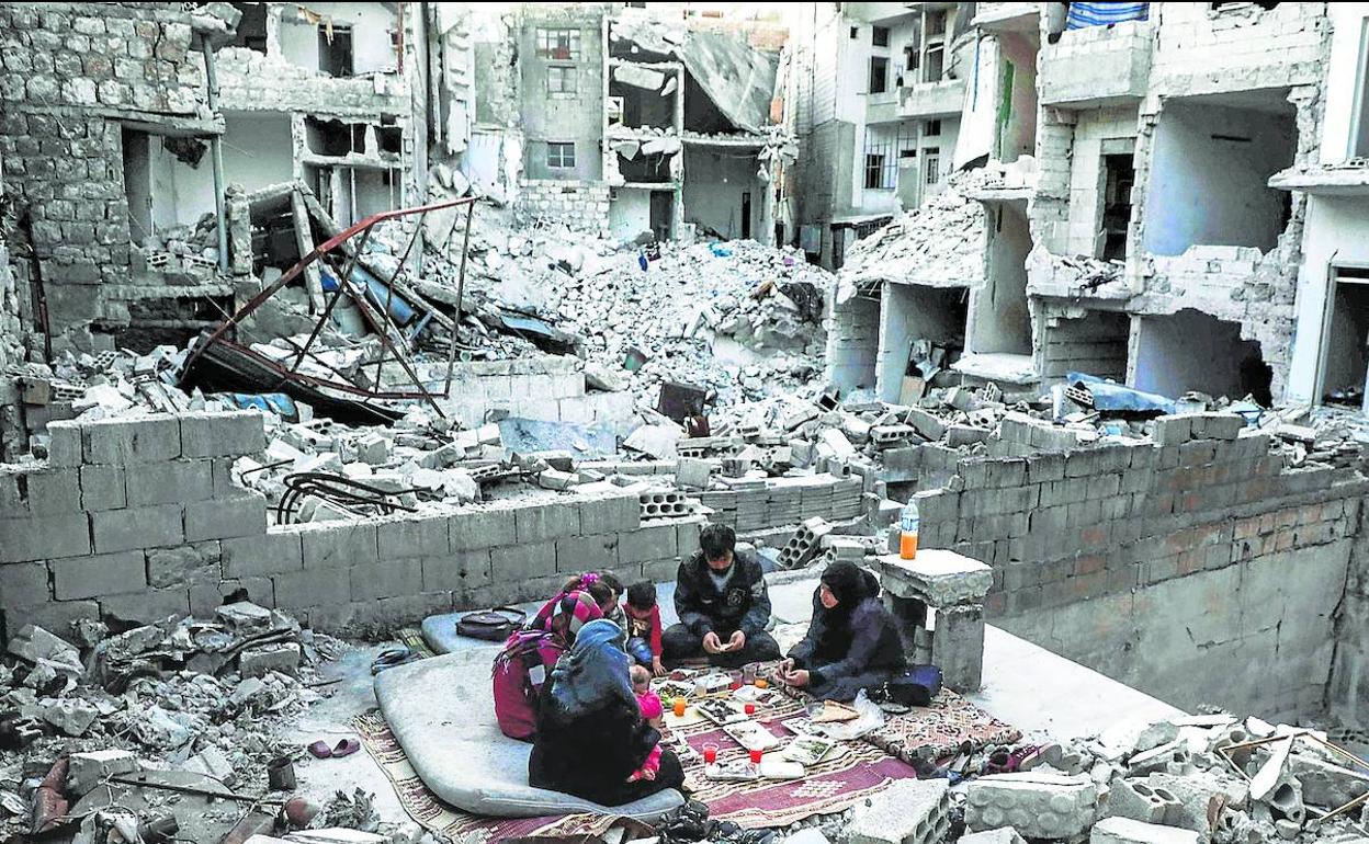 Una familia se reúne entre los escombros de su hogar en Ariha, localidad del sur de Siria, en una imagen de archivo.