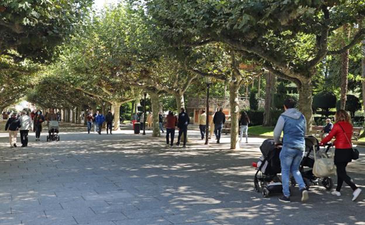 Varios transúntes pasean por el Paseo del Espolón en Burgos 