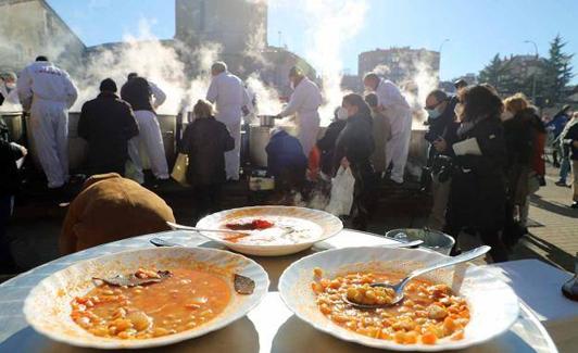 Los cofrades de la Cofradía de San Antón se encargan de repartir las raciones de titos. 