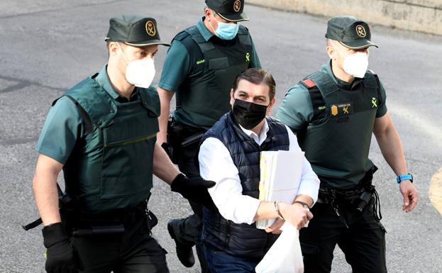 Román llega custodiado a la Audiencia de Madrid durante el juicio.