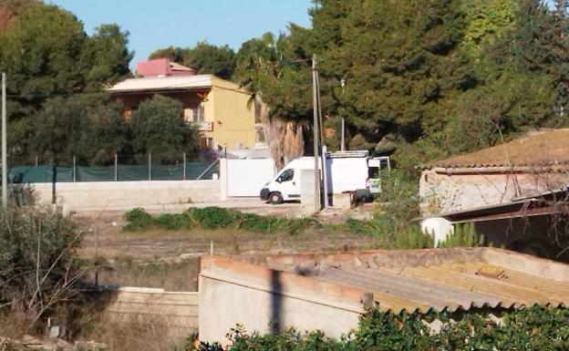 La vivienda (izq. al fondo) en la que se atrincheró el hombre este viernes, junto a una furgoneta blanca de la Policía. 