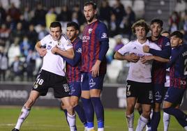 Córdobal y Artola intentan ganar la posición a la defensa de la SD Huesca en el partido de la primera vuelta.