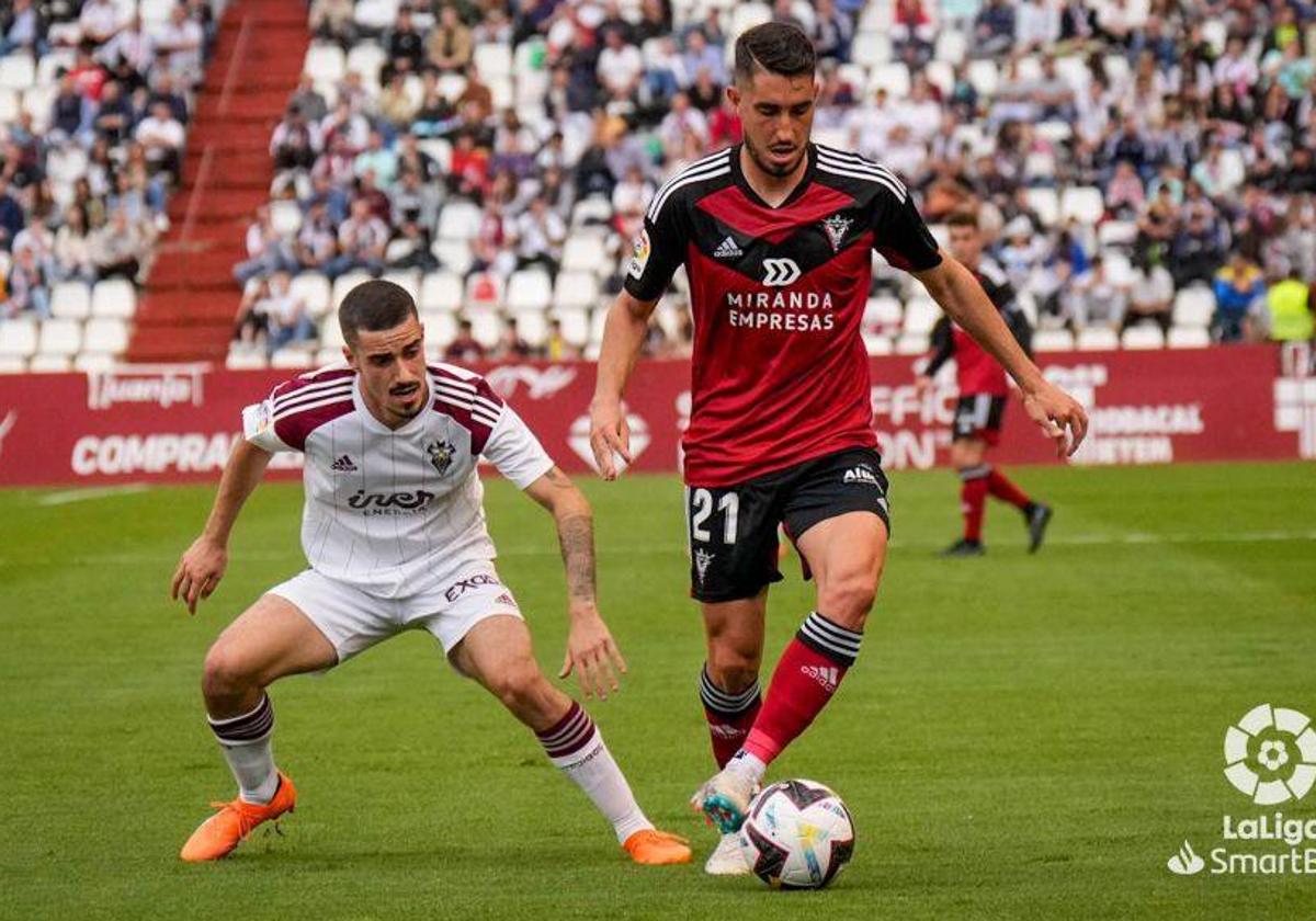 Roberto López encimado por un jugador del Albacete en la derrota de este sábado en el Carlos Belmonte