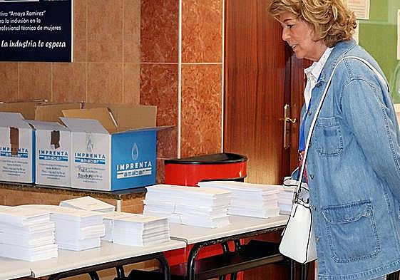 Una mujer consulta las papeletas en un colegio electoral.