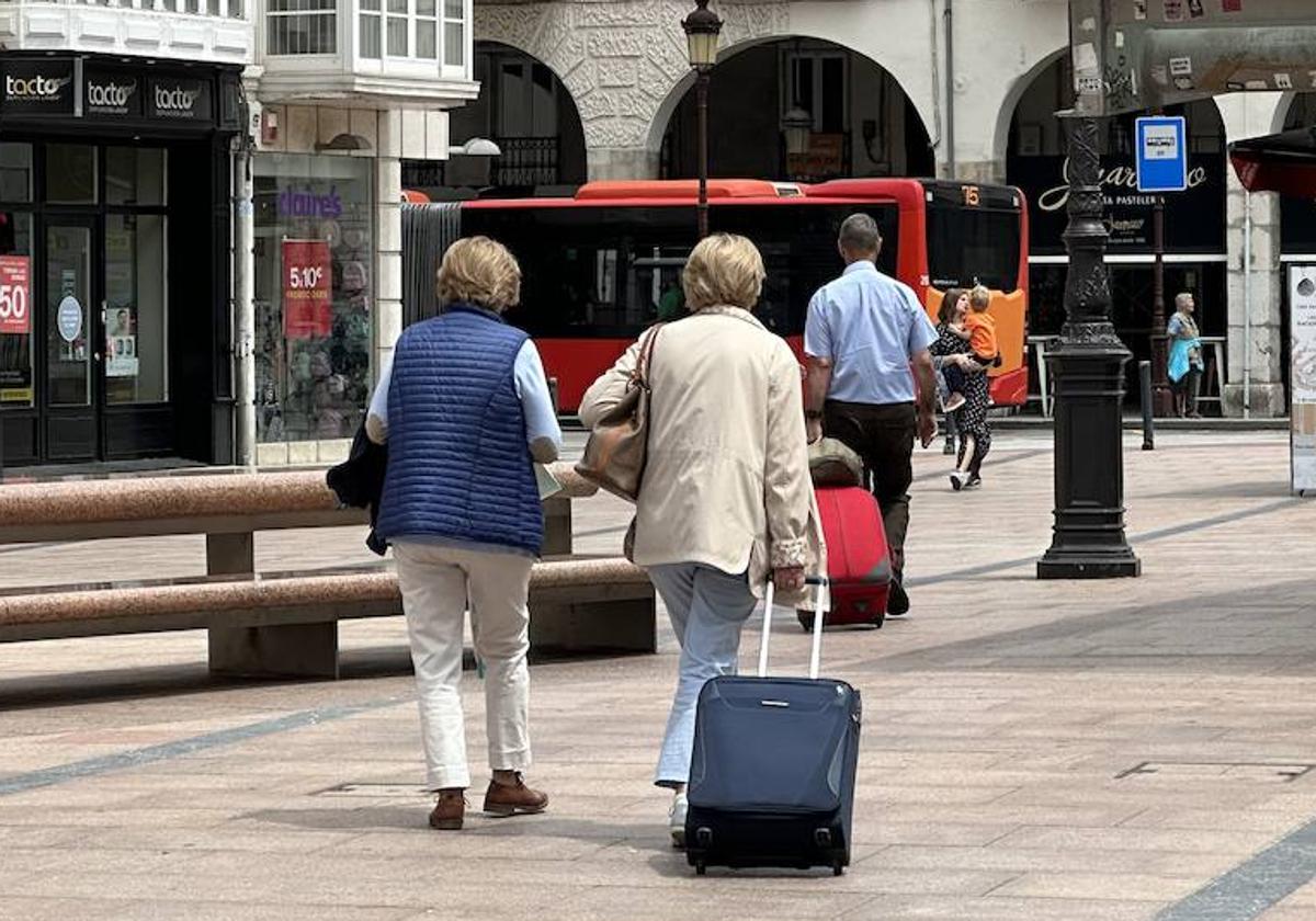 Burgaleses con maletas por el centro de la ciudad.