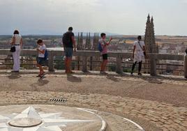 Varios turistas contemplan Burgos desde el mirador del Castillo.