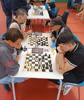 Imagen secundaria 2 - Arriba, los ganadores con sus trofeos, junto al polideportivo que albergó la competición y una foto detalle de una de las partidas. 