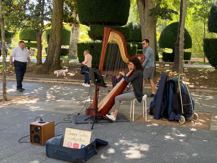 Carmen Escobar tocando el arpa en el paseo del Espolón