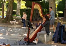 Carmen Escobar tocando el arpa en el paseo del Espolón