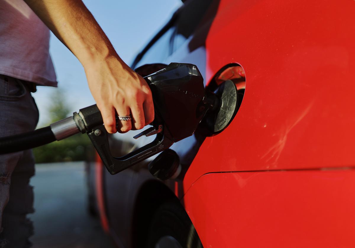 Una persona llenando el depósito del coche