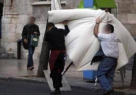 Dos trabajadores luchan contra el viento para recoger una sombrilla en Burgos en una imagen de archivo.