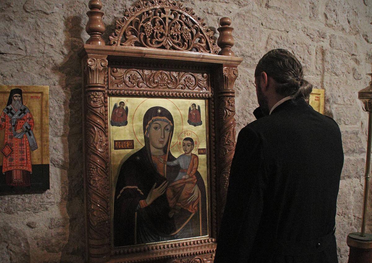 Imagen secundaria 1 - Arriba, el padre católico Ángel, con algunos feligreses. Debajo, el padre Danut y la vecina Leo profesan su fe. 